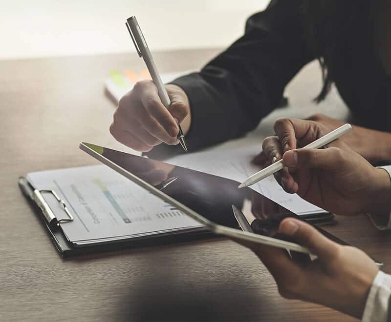 rédaction d'un document par un expert sur feuille et tablette tactile